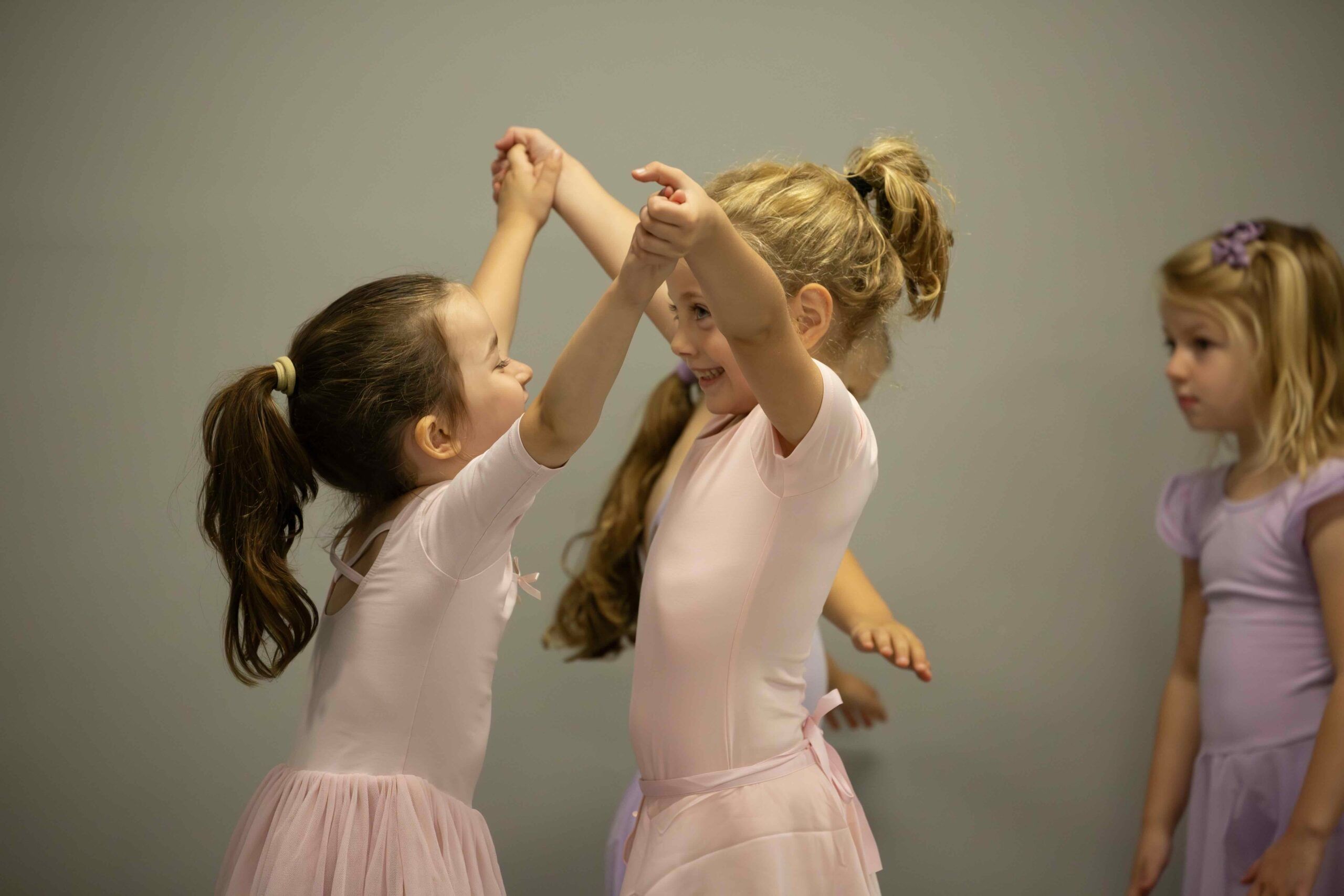 two girls holding hands and dancing