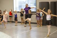 Dance teacher leads children in dance lessons